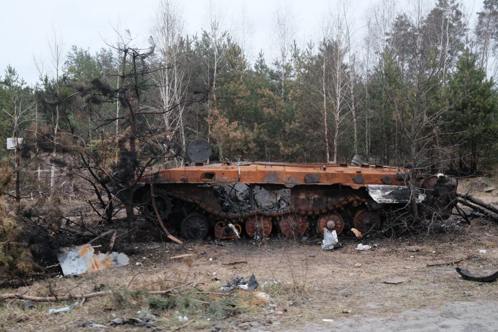 a rusted out truck sitting in the middle of a forest