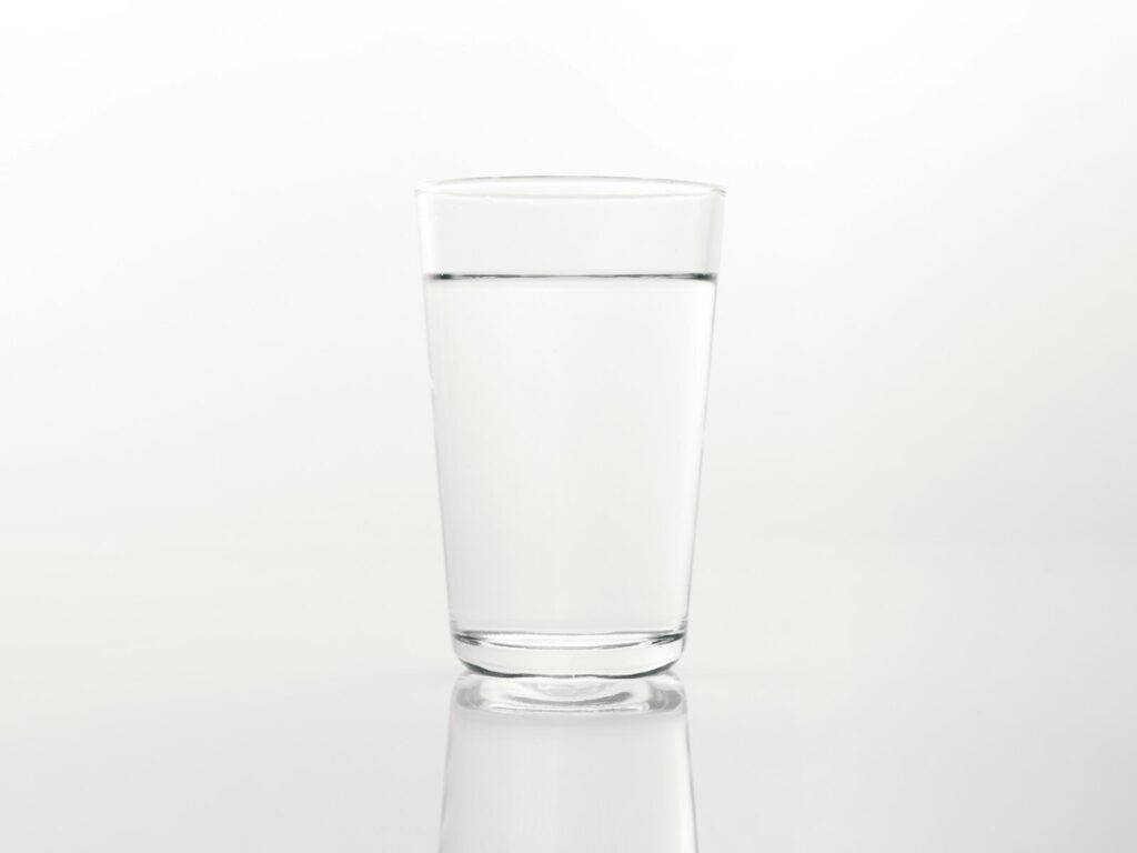 a glass of water on a reflective surface