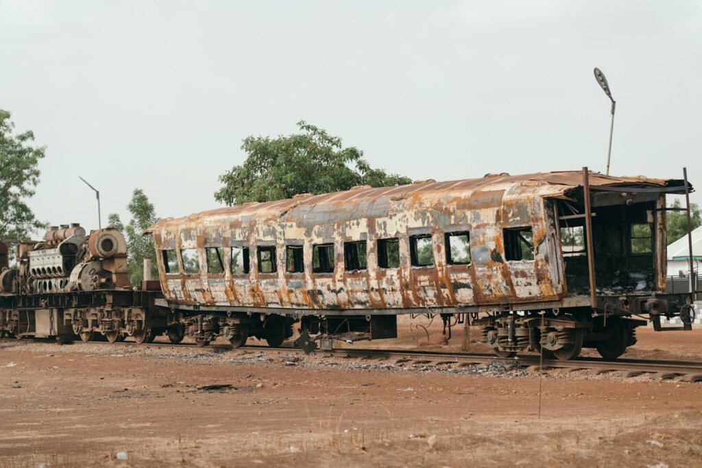 Burnt and rusted train carriage on an old railway track